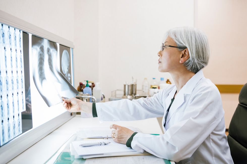 doctor examining xray at light box