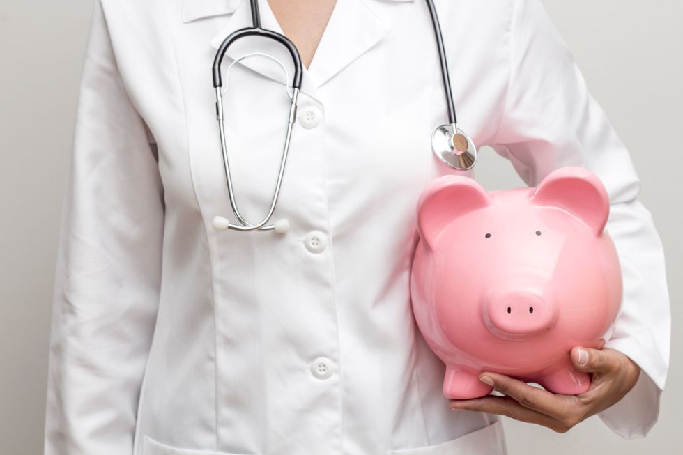 Doctor with piggy bank in hand representing medical costs