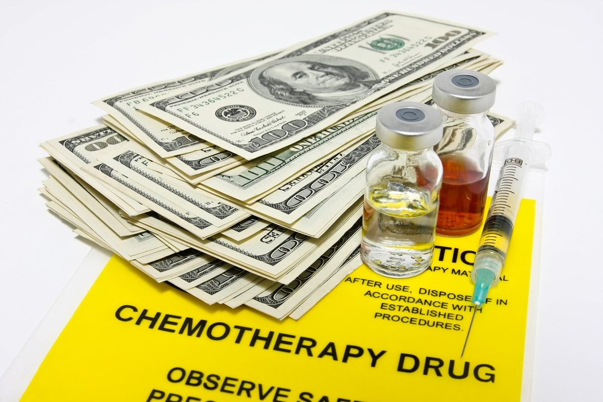 hundred dollar bills and drug vials + syringe on top of a chemotherapy transport bag