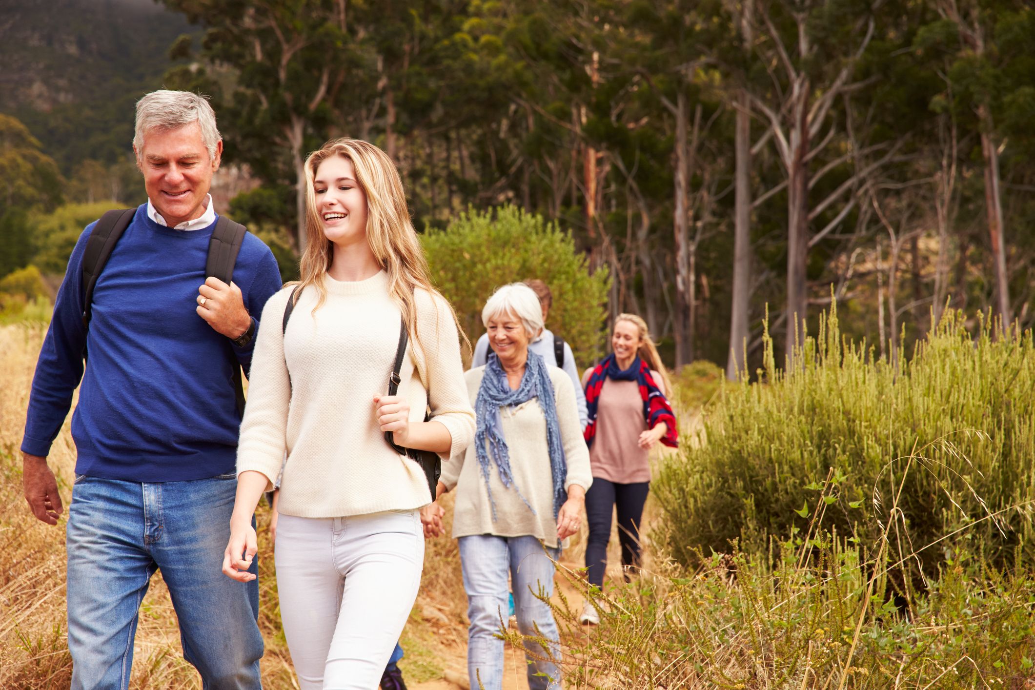 Multi-generation family walking together through a forest