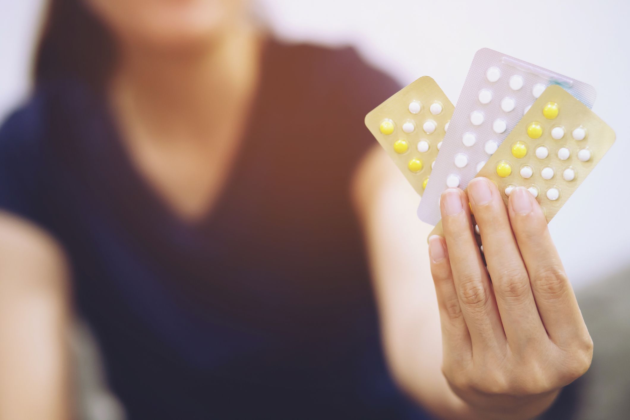 woman holding birth control pills