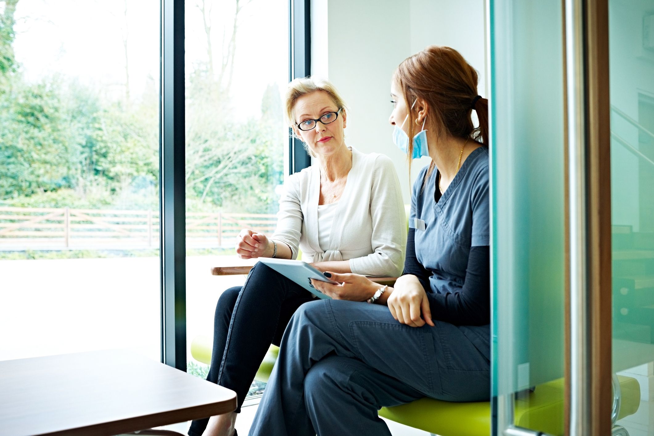 female patient talking with nurse in waiting room