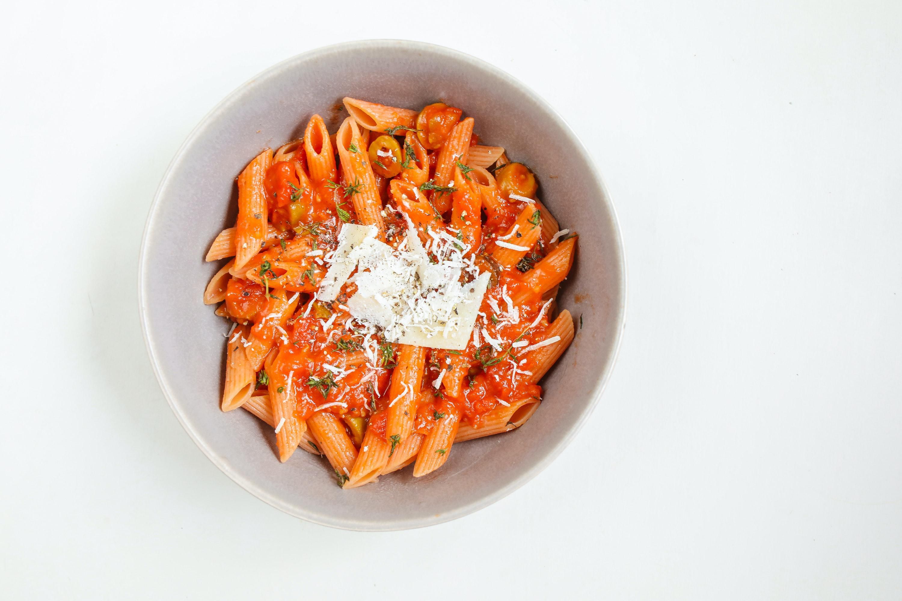 A Delicious Red Macaroni with Grated Cheese in a Bowl