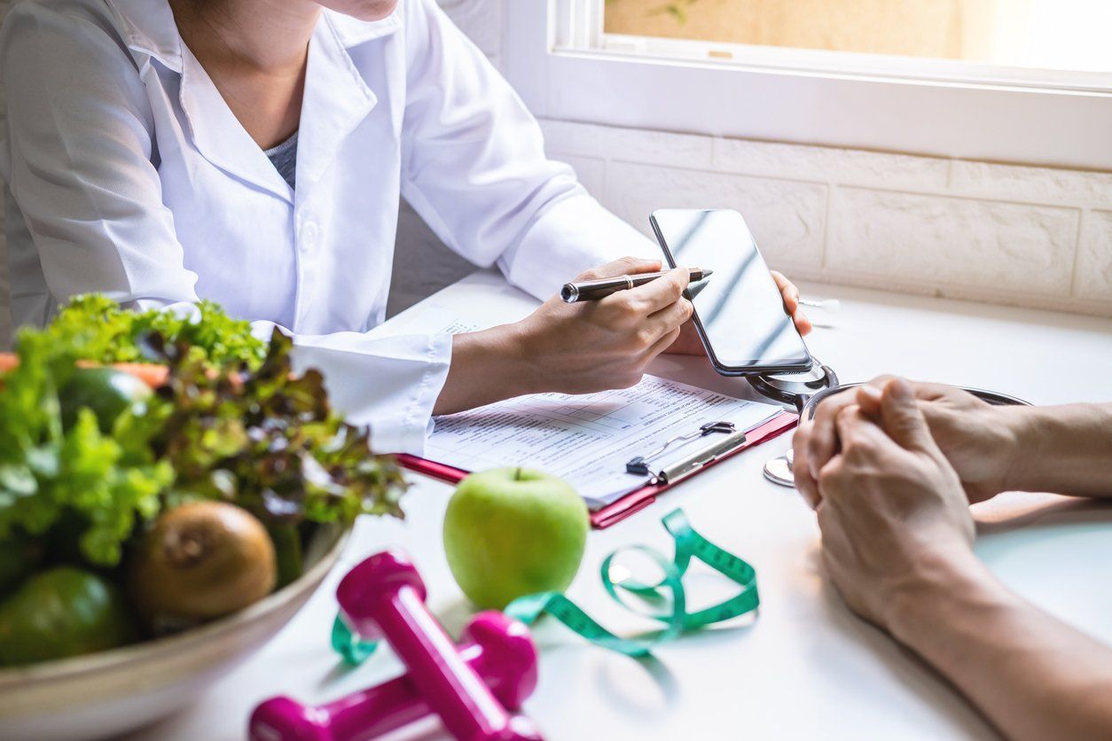 Nutritionist giving consultation to patient with healthy fruit and vegetabl