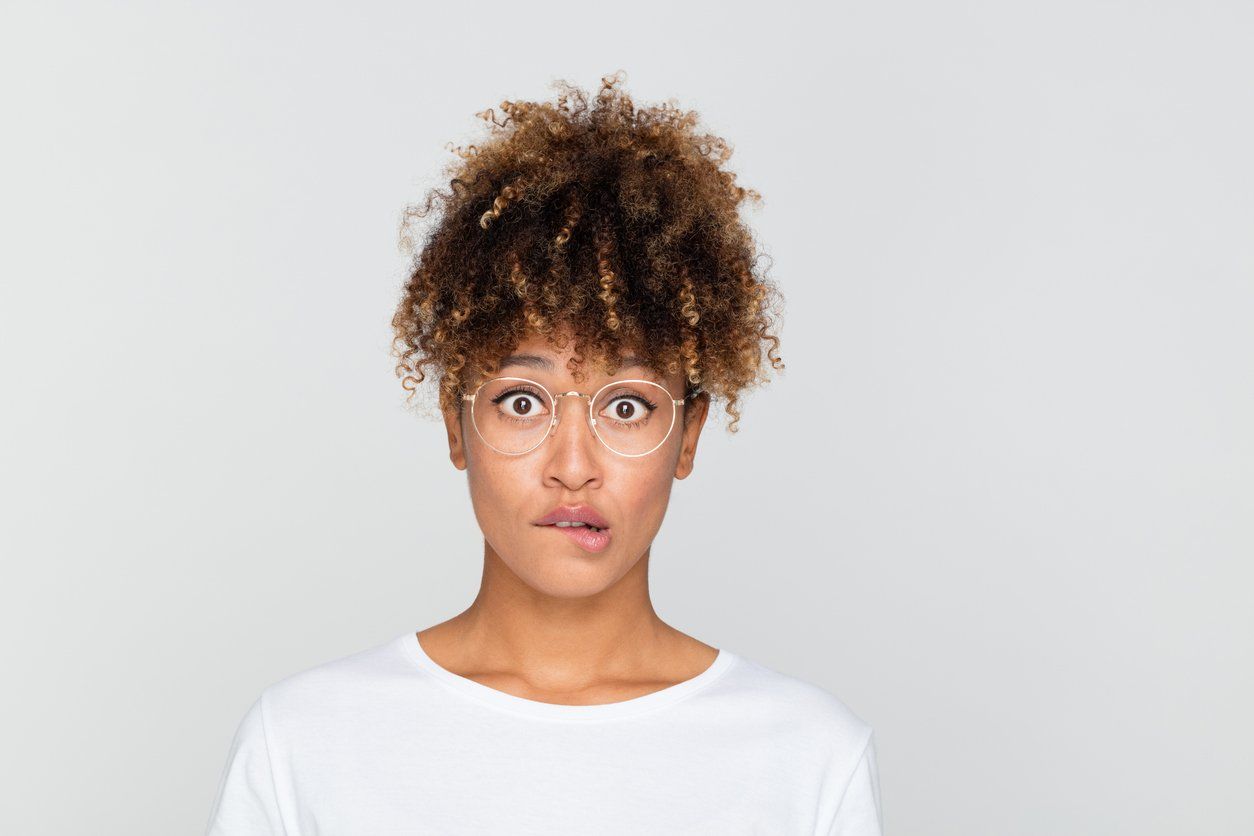 young afro american woman looking nervous, biting her lips