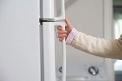 person with their hand on the fridge