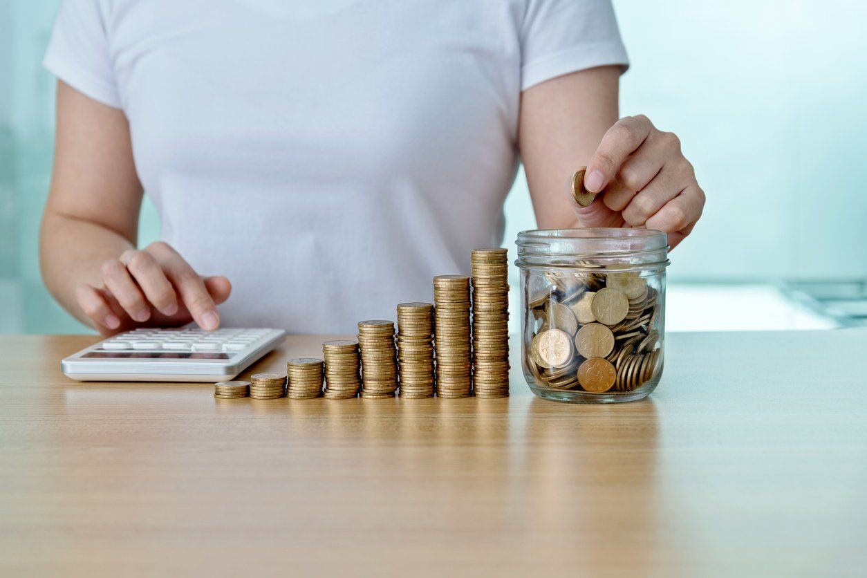 Woman counting coins with calculator