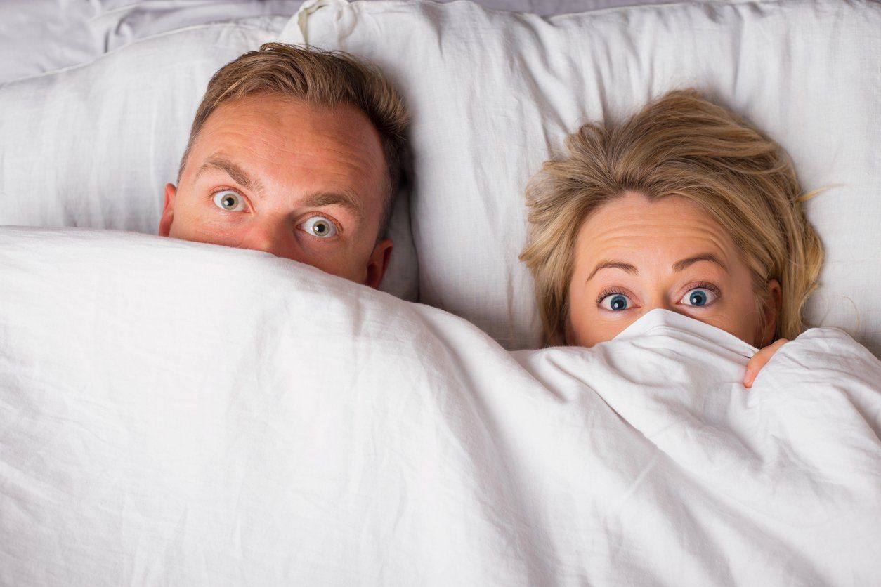 Couple hiding under sheets