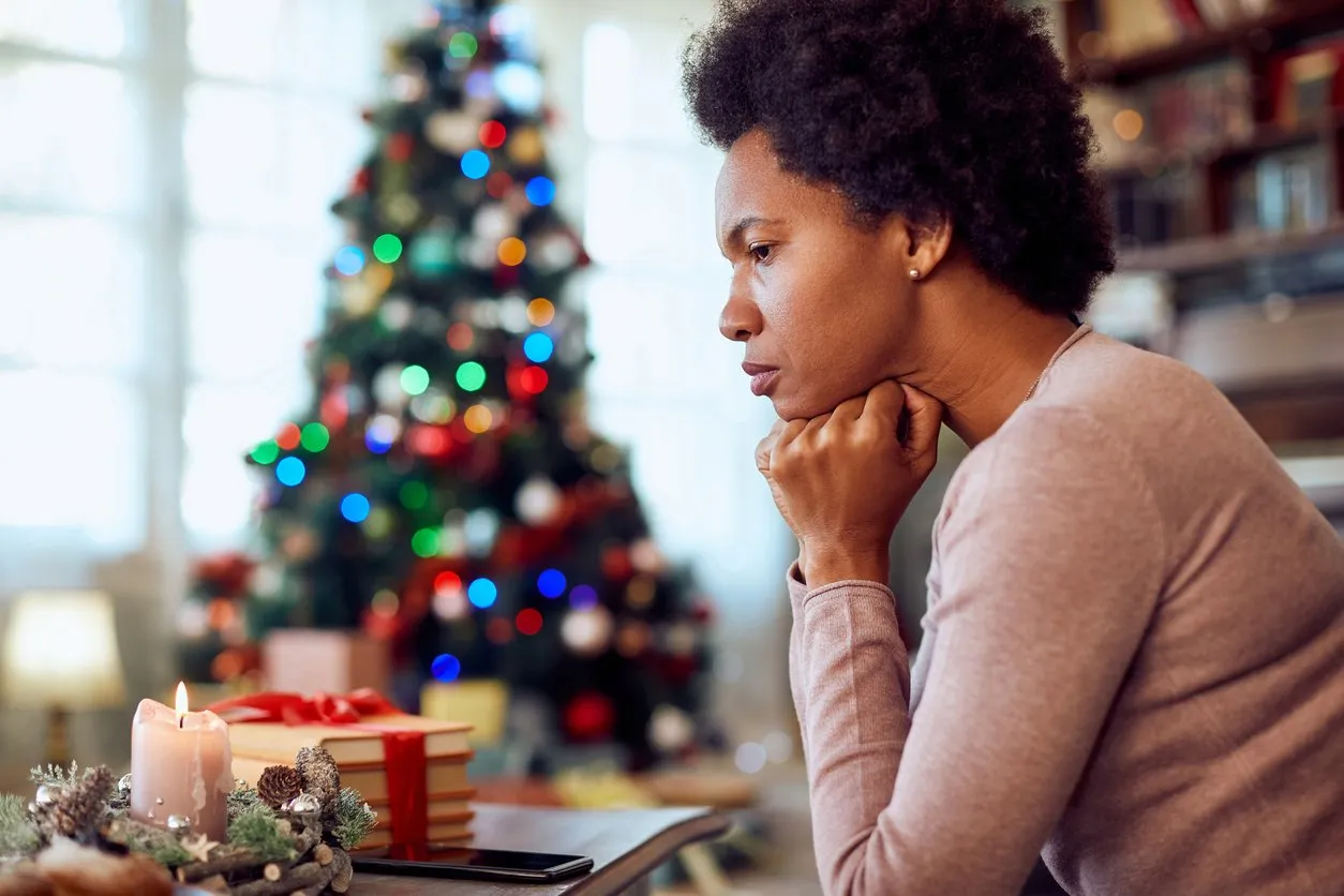 woman thinking of something while spending Christmas alone at home