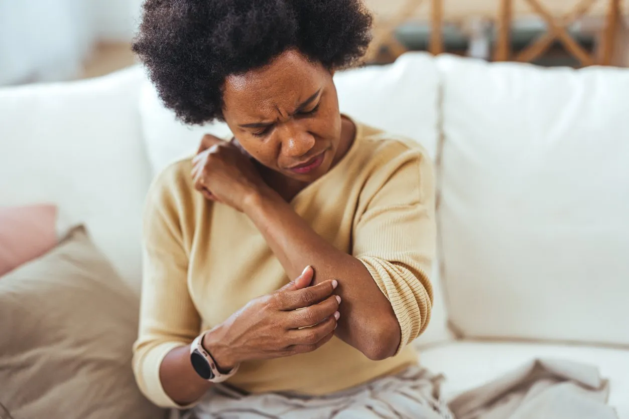 Woman Scratching Arm While Experiencing Skin Irritation