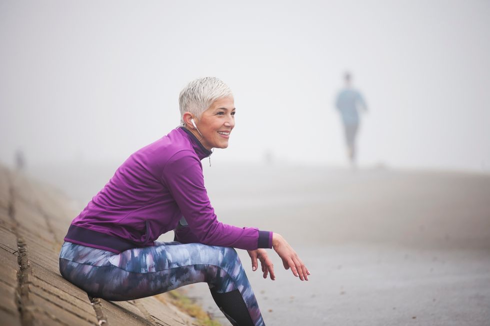 menopausal woman taking a rest while exercising at beach