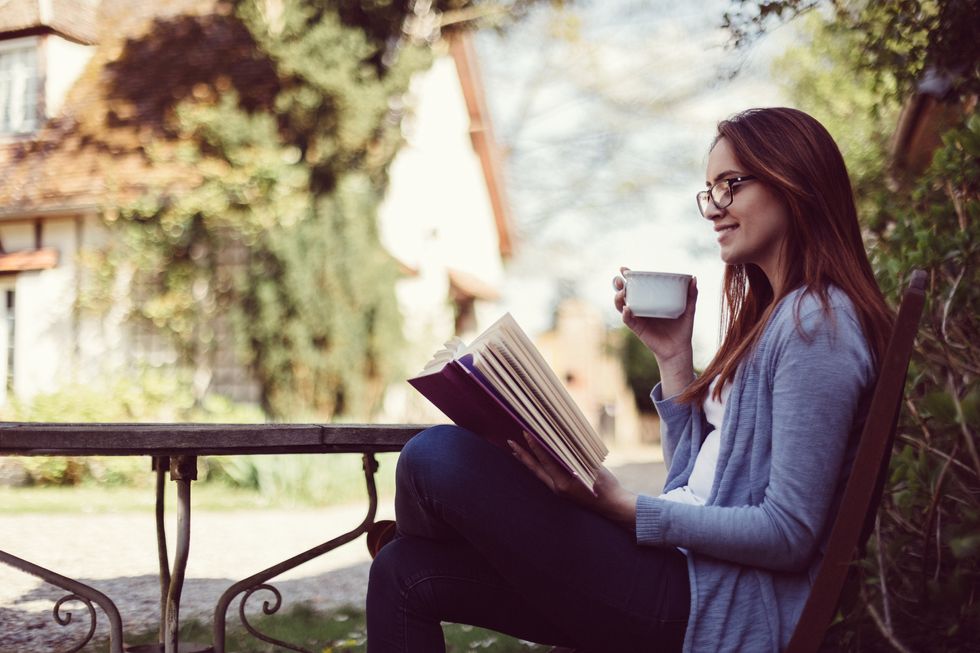 Woman drinking tea and reading a book