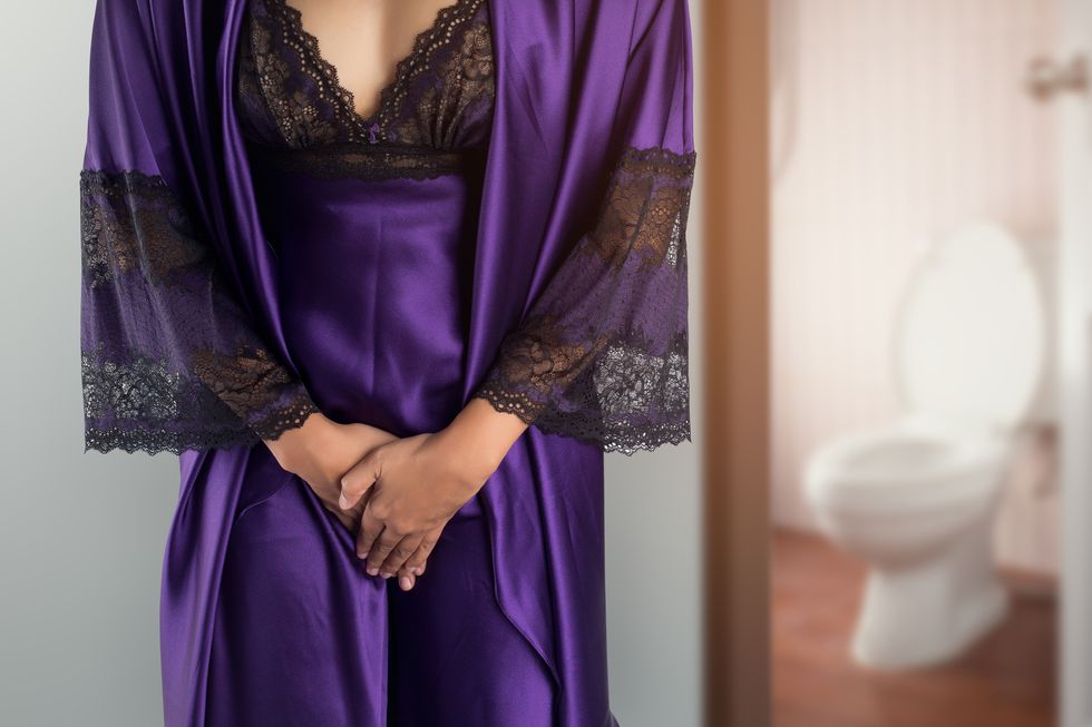 woman in purple satin sleepwear and robe wake up for go to restroom