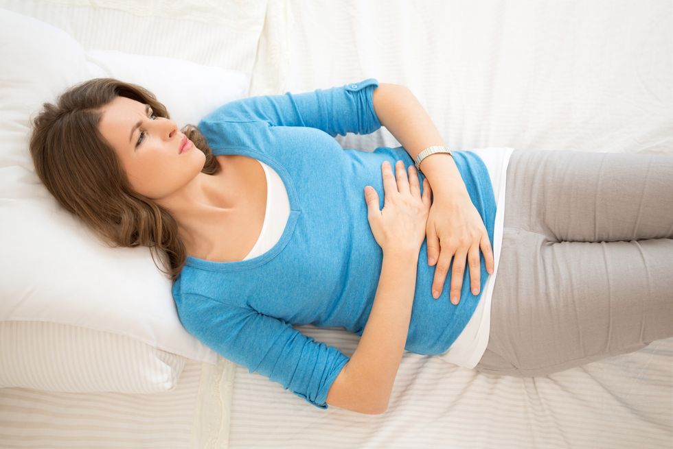 woman laying in bed suffering from a heavy period