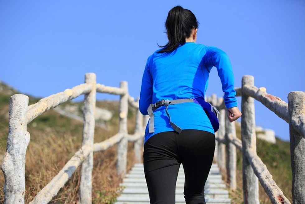 woman running up on mountain stairs to peak