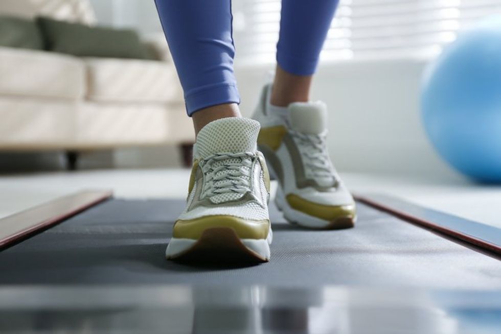 Woman training on walking treadmill at home